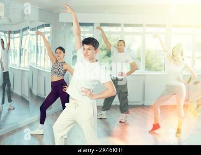 Young Hispanic fitness instructor leading dynamic zumba class Stock Photo