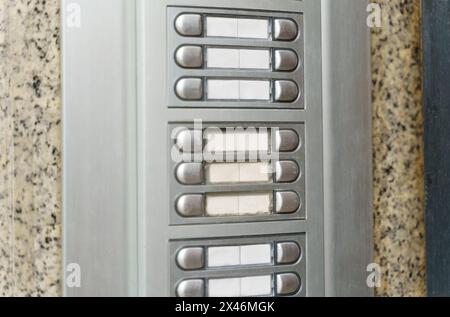 A detailed view of an intercom phone attached to a wall, showing buttons and a speaker. Stock Photo