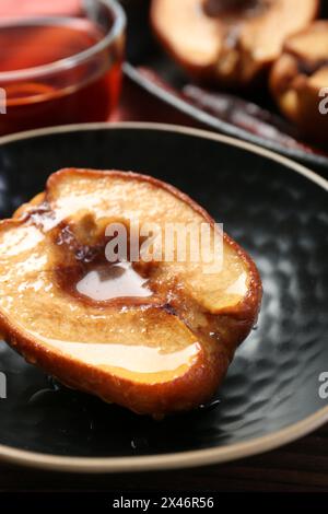 Tasty baked quince with honey in bowl on table, closeup Stock Photo