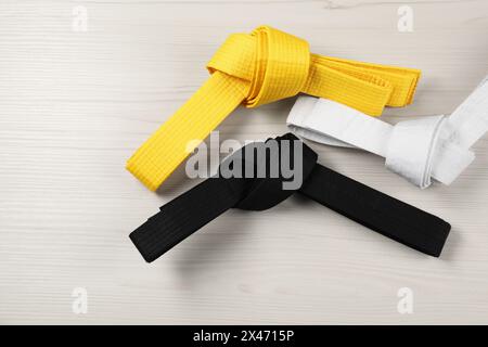 Colorful karate belts on wooden background, flat lay Stock Photo