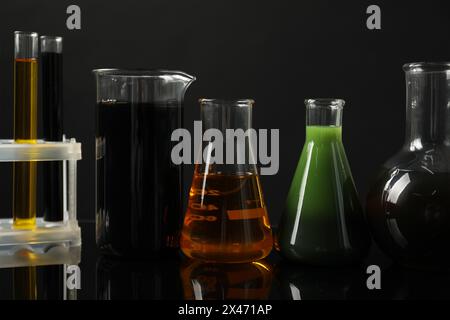 Laboratory glassware with different types of oil on mirror table ...