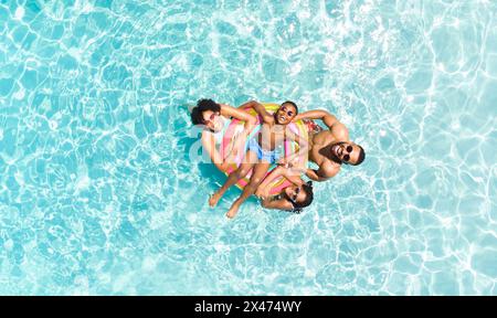 Diverse family enjoys a sunny day at the pool, with copy space Stock Photo