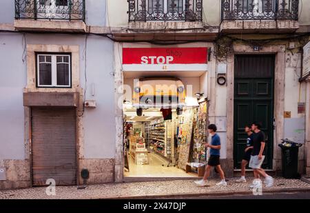 Small tourist shop with the front of a small European automobile suspended over the entrance on Rua do Lareto street in the Bairro Alto district of Lisbon, Portugal. Stock Photo