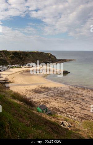 Porth Nefyn harbour and Nefyn beach viewed from on top of a cliff in evening sunlight. Nefyn is a village situated on the LLyn Peninsula in North Wale Stock Photo