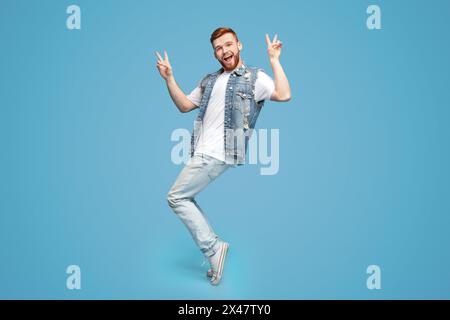 Awesome guy showing peace gesture and standing on tiptoes Stock Photo