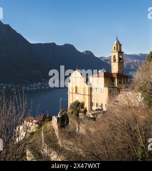 A landscape with the beautiful yellow church of Pognana Lario, a picturesque village on the Como Lake between Como and Bellagio, Italy Stock Photo