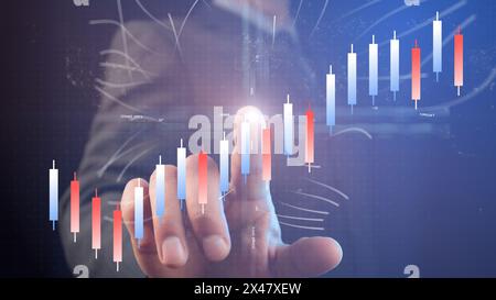 A businessman points a finger with a light point at the center of the coordinate system against the background of a chart of growing blue and red Chin Stock Photo