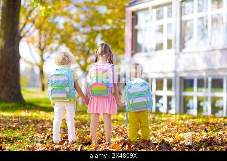 Children go back to school. Start of new school year after summer vacation. Boy and girl with backpack and books on first school day. Stock Photo