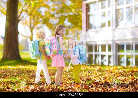 Children go back to school. Start of new school year after summer vacation. Boy and girl with backpack and books on first school day. Stock Photo