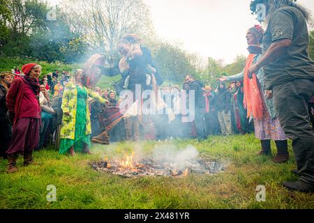 People jump the fire during the Beltane celebrations at Glastonbury ...