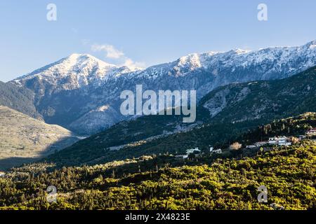 Snow capped peaks including Mount Cika rising above hillside village, Palase, near Dhermi, Albania Stock Photo