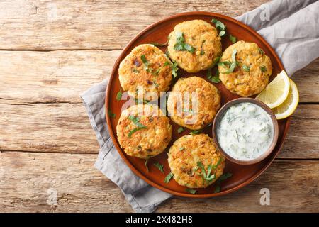 Chickpea Fritters with Yoghurt Dipping Sauce close-up in plate on the table. Horizontal top view from above Stock Photo