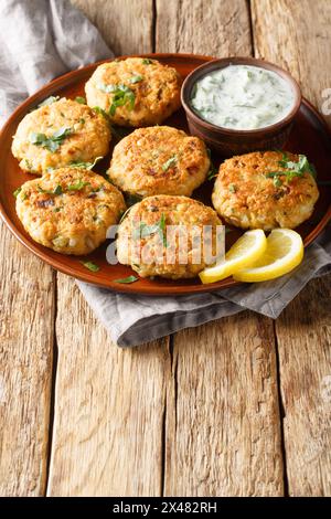 Vegetarian chickpeas fritters with garlic herb yogurt sauce close-up in plate on the table. Vertical Stock Photo