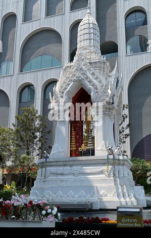 The Trimurti statue, a replica of a classical Ayutthaya Indian sculpture, with offerings of red roses, where many Thais come to pray for love, Bangkok Stock Photo