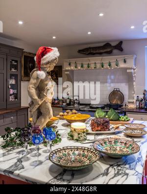 Statue in santa hat with food preparation in Dorset family home at Christmas, England, UK Stock Photo