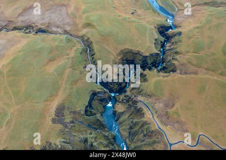 Between the hills in Iceland flows winding blue river, branch of mountain streams. View from drone Stock Photo