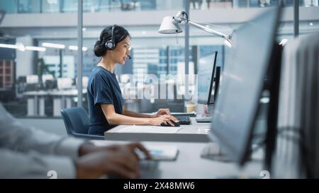 Professional Investment Traders Talking into Headset, Working on Computer with Screen Showing Finance Statistics, Charts Strategy, Stock Market, Telemarketing. Big Office Call Center. Stock Photo