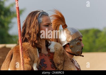 AQUILEIA, Italy - June 22 2014: Close-up of a young girl seen in profile next to a soldier at the local annual historical reenactment Stock Photo