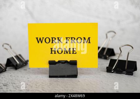 Work from home text on standing yellow paper. Working culture concept. Stock Photo