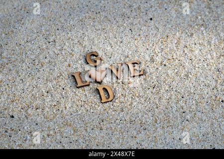 God is love text on the sand Stock Photo