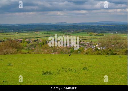 Far-reaching views over West Sussex countryside from South Downs Way with the village of Amberley with castle, now a hotel, situated in the valley. Stock Photo