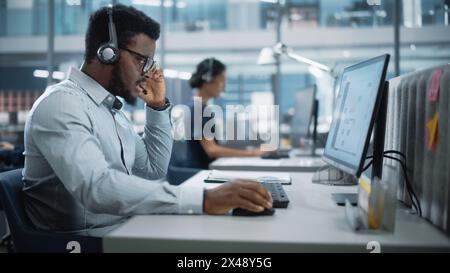 Professional Investment Traders Talking into Headset, Working on Computer with Screen Showing Finance Statistics, Charts Strategy, Stock Market, Telemarketing. Big Office Call Center. Stock Photo