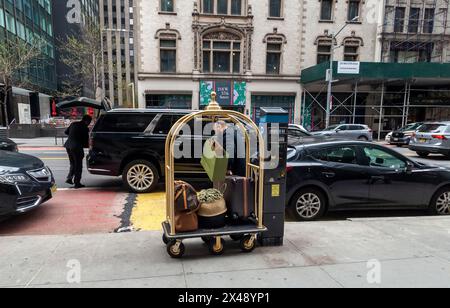 Doorman loads luggage and other possessions outside of a hotel in Midtown Manhattan in New York on Sunday, April 21, 2024 (© Richard B. Levine) Stock Photo