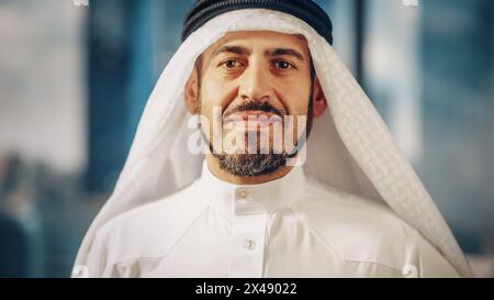 Portrait of Successful Arab Businessman in Traditional Outfit Gently Smiling, Wearing White Kandura and Black Agal Keeping a Ghutra in Place. Saudi, Emirati, Arab Businessman Concept. Stock Photo