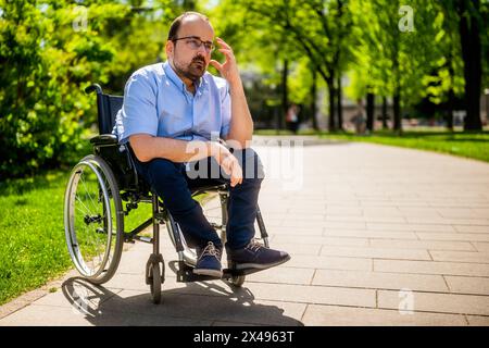 Portrait of man in wheelchair. He is worried and thoughtful. Stock Photo