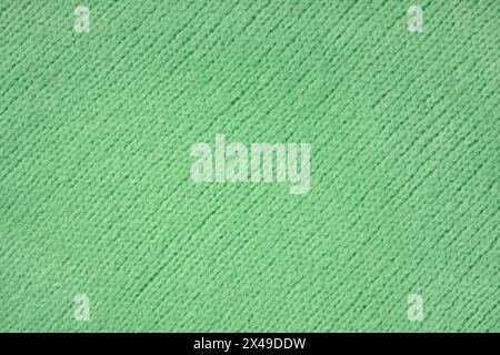 Green knitted woolen jersey fabric with diagonal weaving, sweater, pullover texture background. Fabric abstract backdrop, cloth wallpaper Stock Photo