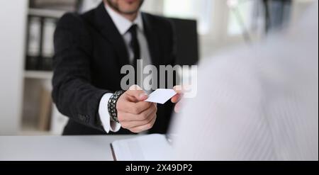 man give businesscard in office to his partner Stock Photo
