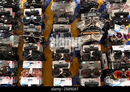 Rows of cheap sunglasses for sale on display in shop Stock Photo