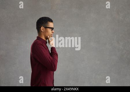 Pensive african american customer thinking over special offer, touching chin Stock Photo