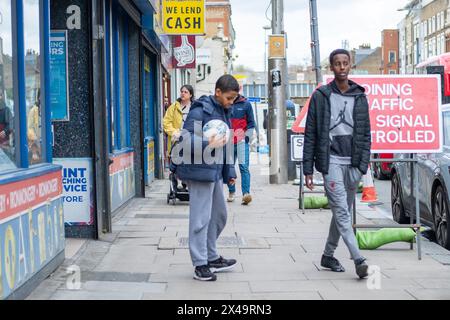 LONDON- APRIL 4th, 2024:  Kilburn High Road in NW6 North West London. A long and busy a high street of shops Stock Photo