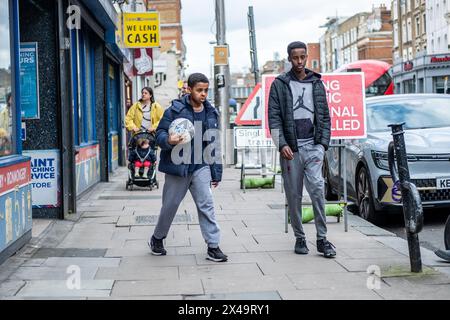 LONDON- APRIL 4th, 2024:  Kilburn High Road in NW6 North West London. A long and busy a high street of shops Stock Photo