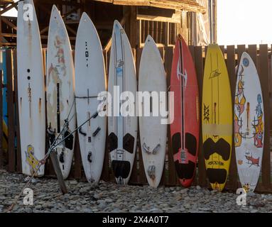 Novorossiysk, Russia - 22 August 2023 SUP boards stand nearby along the fence, drying. Stock Photo