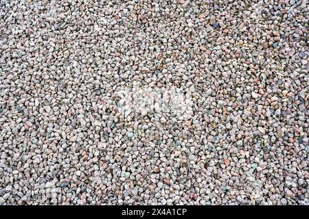 Closeup of abstract colorful grey fine granite gravel pebbles, background of gravel surface texture, crushed gravel texture Stock Photo