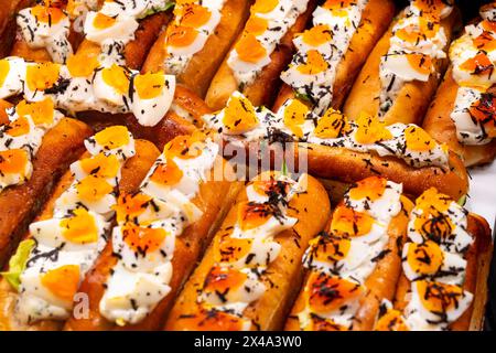 Fresh baked brioche buns filled with eggs and truffles ready to eat in food hall, London, Covent Garden market, UK Stock Photo