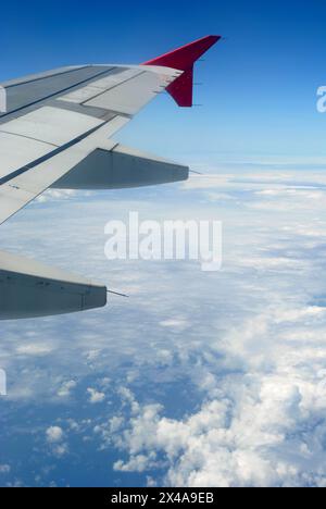 aerial view of an airplane wing above the clouds against a deep blue sky showcasing the elegance and aerodynamics of flight Stock Photo