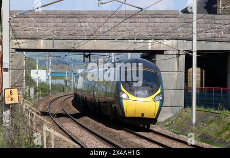 Avanti West Coast pendolino electric train with 12:40 from Edinburgh to London Euston on 1 May 2024 on West Coast Main Line railway at Carnforth. Stock Photo