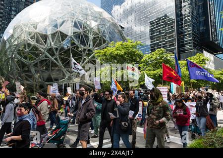 Seattle, USA. 1st May 2024. Protestors in the Seattle May Day March gathered at 10:00am in the Westlake Shopping district. The group marched through the city stopping at the Amazon Spheres Campus for a mass die-in for Palestine. The group then continued on to the Hyatt Hotel to denounce the meeting of Gas and Oil pipeline officials. Credit: James Anderson/Alamy Live News Stock Photo