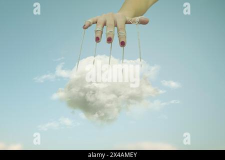 hand holding a cloud trapped between threads transforming it into a puppet, abstract concept Stock Photo