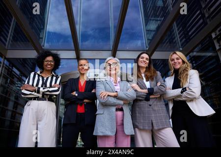 Formal work group of diverse business women standing in a row looking serious to the camera Stock Photo