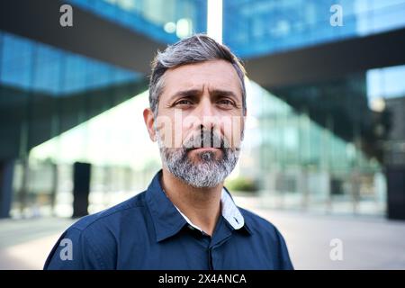 A mature Caucasian businessman in a suit and tie, dress shirt and blazer standing Stock Photo