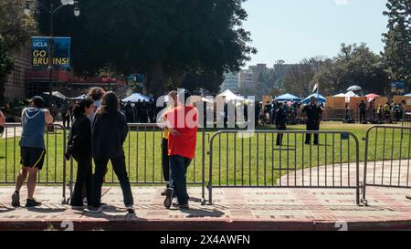 Los Angeles, USA. 1st May, 2024. People standing outside the perimenter of a protest at UCLA. An encampment protesting the war in Gaza has been established on the Royce Quad on the campus of UCLA, the University of California, Los Angeles. Protestors set up tents and signs on the quad in protest of the war between Israel and Palestine. Credit: Stu Gray/Alamy Live News. Stock Photo