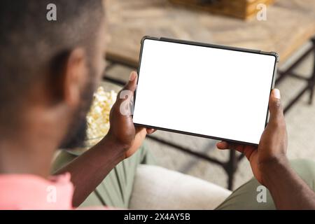 African American man holding a tablet with a blank screen at home with copy space Stock Photo