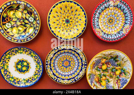 Collection of colorful plates with intricate designs hanging on a wall. The plates are arranged in a way that creates a sense of harmony and balance. Stock Photo