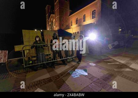 April 30, 2024, Los Angeles, California, USA: Pro-Palestine protesters put a barrier back that was breached. Pro-Israel counter protesters clashed with Pro-Palestinian protesters who have set up an encampment near Royce Hall at UCLA in Los Angeles, Calif. The riot went on for hours in the night on April 30 lasting until the morning hours of May 1, until a couple hundred law enforcement officers arrived including university police, California Highway Patrol, LAPD and Beverly Hills police. The protesters brandished sticks and other items like umbrellas, fought, pulled down barriers, threw firewo Stock Photo