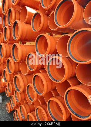 Orange background of PVC sewer pipes for the construction of sewage networks Stock Photo