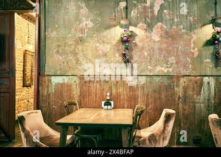 A spectacular photo of a wooden table and upholstered chairs in the bar. Shabby walls with space to copy. High quality photo Stock Photo